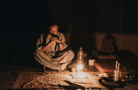 Shipibo shaman meditating by candlelight